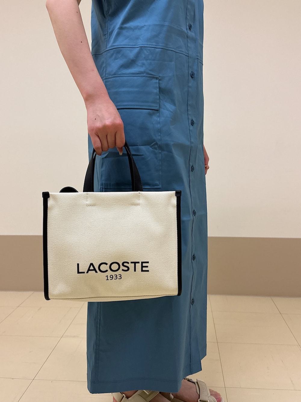 ベージュ系のサンダル、ホワイト系のトートバッグ、ブルー系のシャツワンピースを着用したレディースの春コーディネートの4枚目の写真