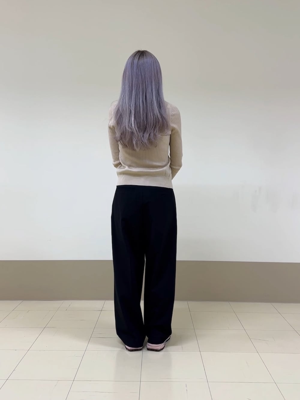 ブラック系のハンドバッグ、ブラック系のパンツ、ピンク系のスニーカーを着用したレディースの冬コーディネートの2枚目の写真