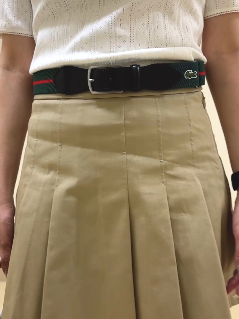 ホワイト系のバッグ、ベージュ系のスカート、ホワイト系のポロシャツを着用したレディースの夏コーディネートの5枚目の写真