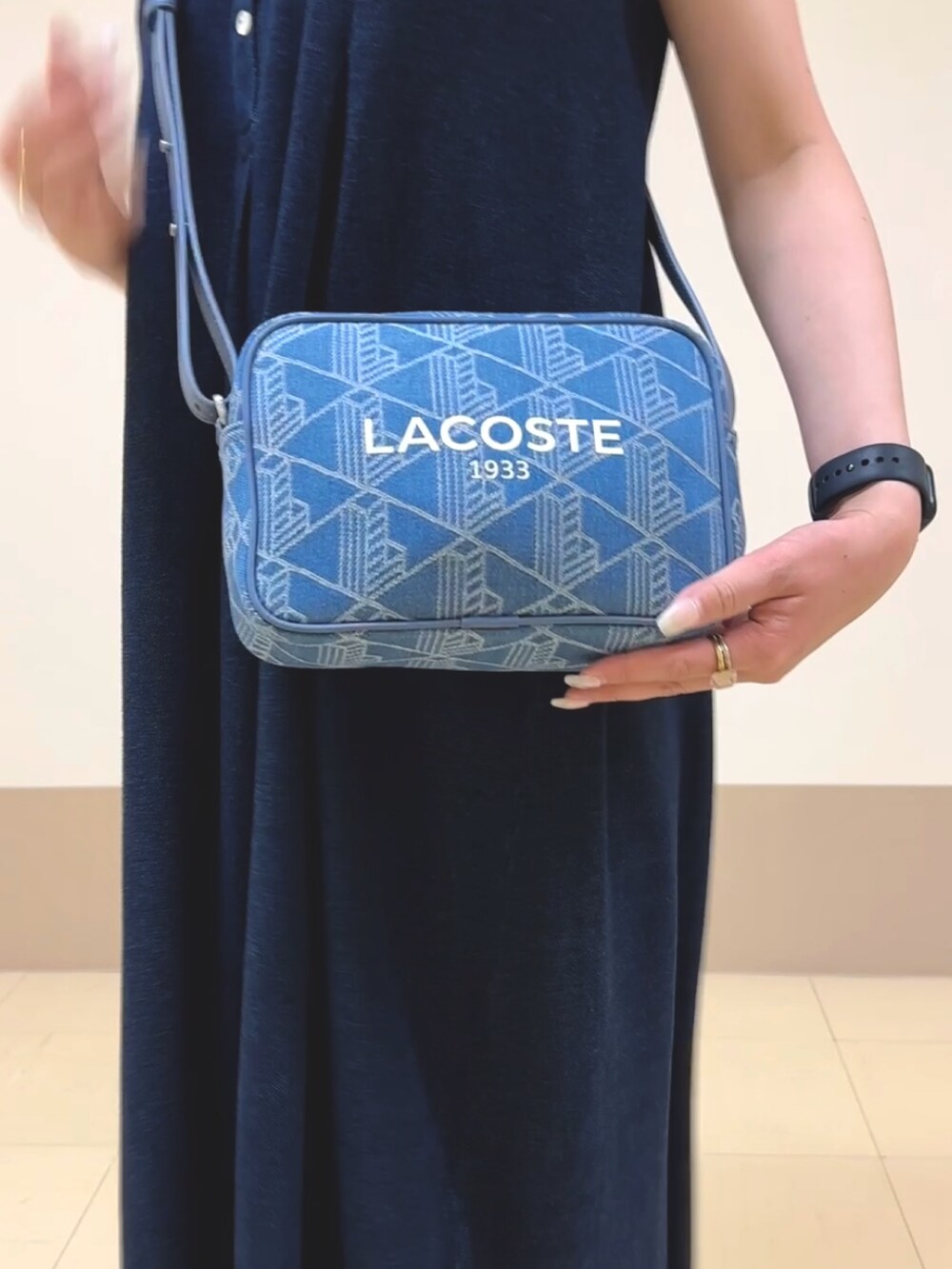 ブルー系のワンピース、ブルー系のトートバッグ、ピンク系のスニーカーを着用したレディースの夏コーディネートの4枚目の写真