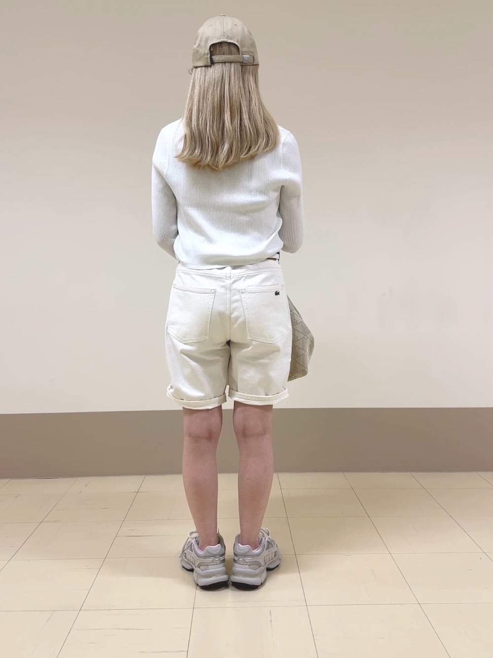ホワイト系のデニムパンツ、ベージュ系のボストンバッグ、ホワイト系のカーディガン/ボレロを着用したレディースの夏コーディネートの2枚目の写真