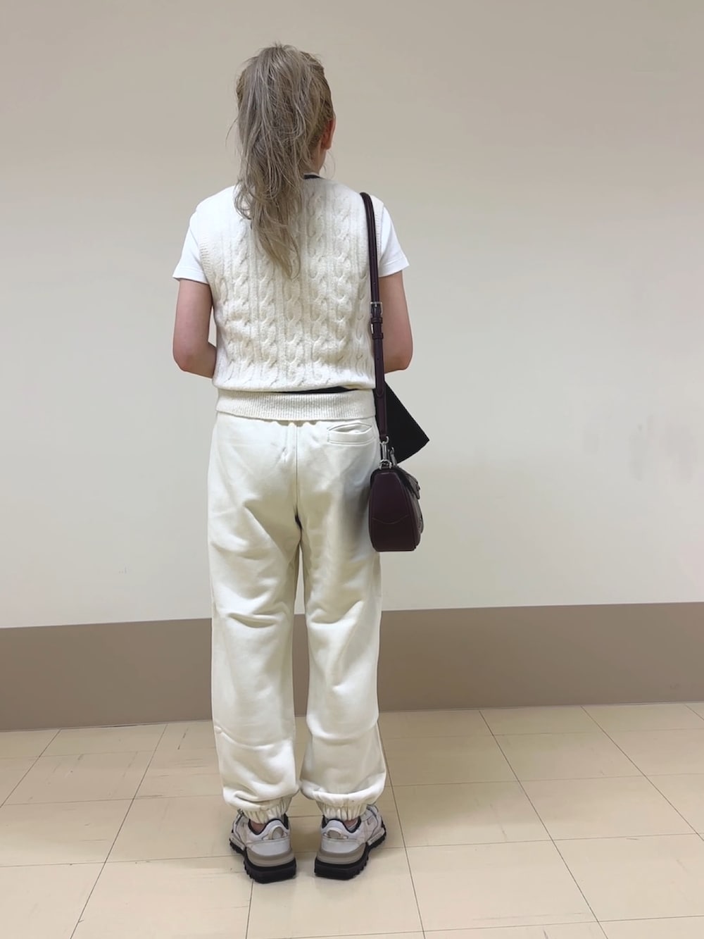 ホワイト系のスウェットパンツ、ベージュ系のスニーカー、ブラウン系のショルダーバッグを着用したレディースの秋コーディネートの5枚目の写真
