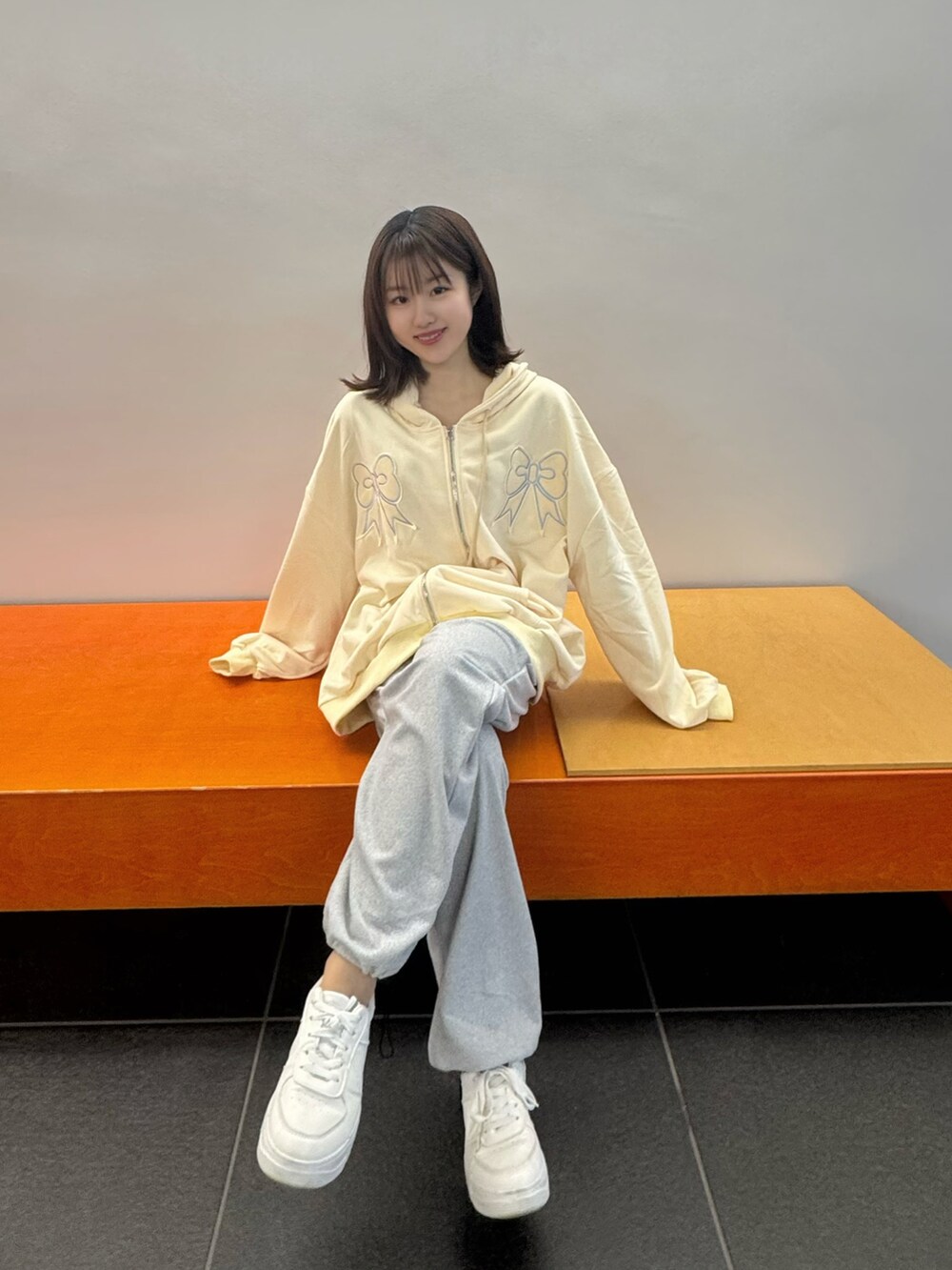 ホワイト系のパーカー、グレー系のスウェットパンツを着用したレディースの冬コーディネートの3枚目の写真