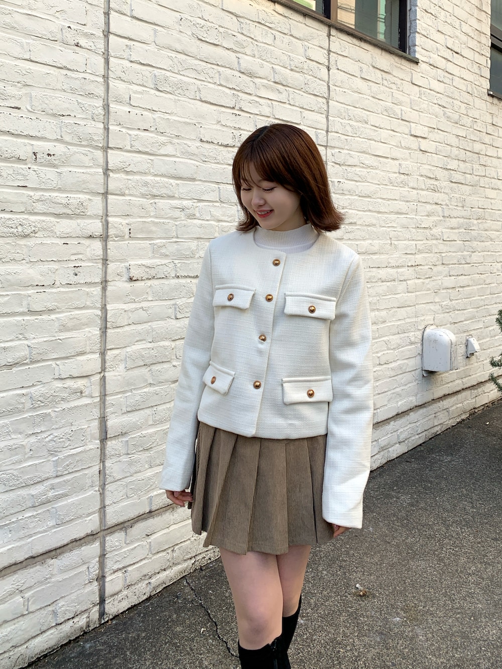 ベージュ系のスカート、ホワイト系のジャケット/アウターを着用したレディースの冬コーディネートの3枚目の写真