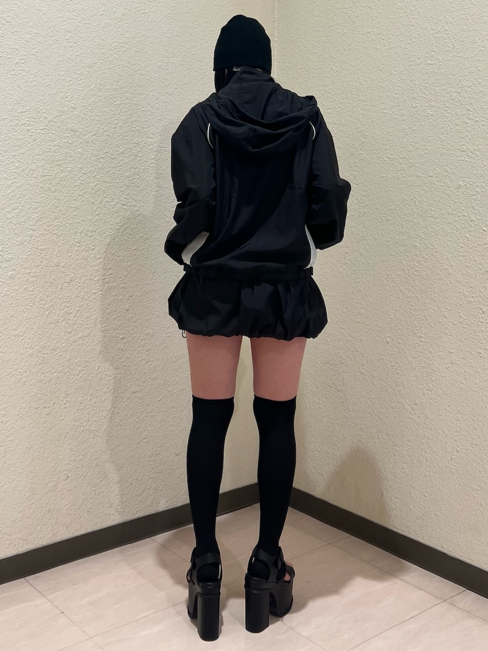 ブラック系のスカート、ブラック系のブルゾン、ブラック系のサンダルを着用したレディースの春コーディネートの3枚目の写真