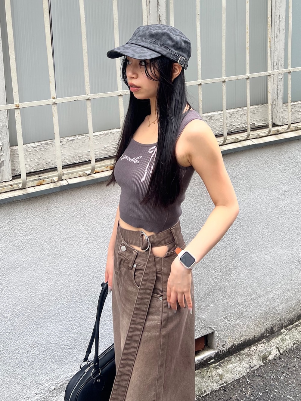 ブラウン系のデニムパンツ、ブラック系のサンダル、ブラック系のハンドバッグを着用したレディースの夏コーディネートの4枚目の写真