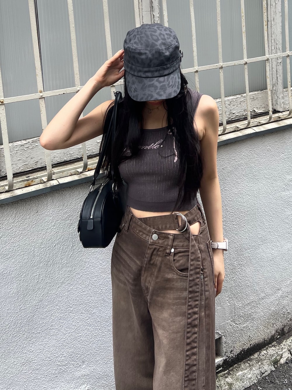 ブラウン系のデニムパンツ、ブラック系のサンダル、ブラック系のハンドバッグを着用したレディースの夏コーディネートの5枚目の写真