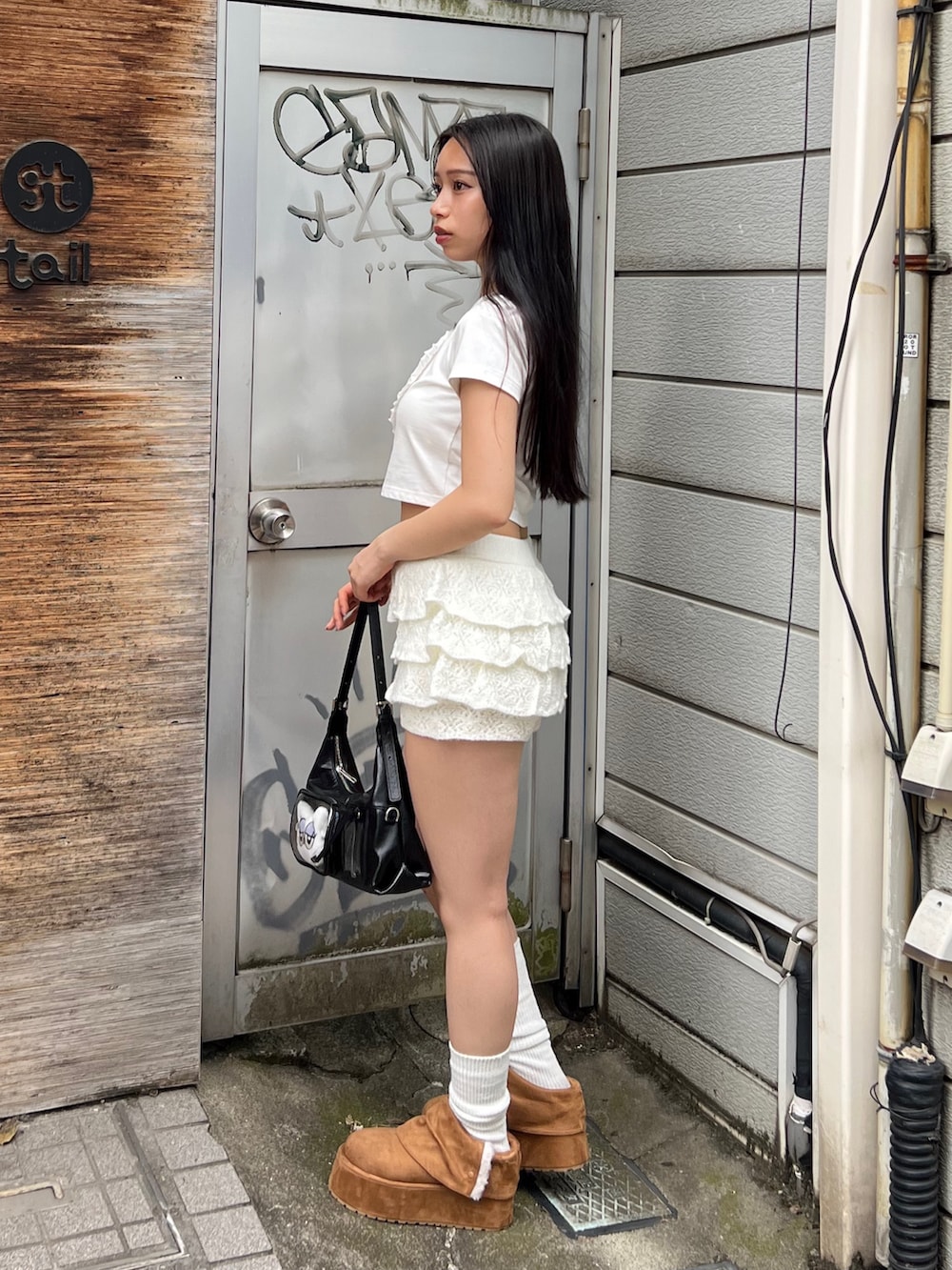 ホワイト系のTシャツ/カットソー、ホワイト系のスカート、ブラック系のハンドバッグを着用したレディースの秋コーディネートの2枚目の写真