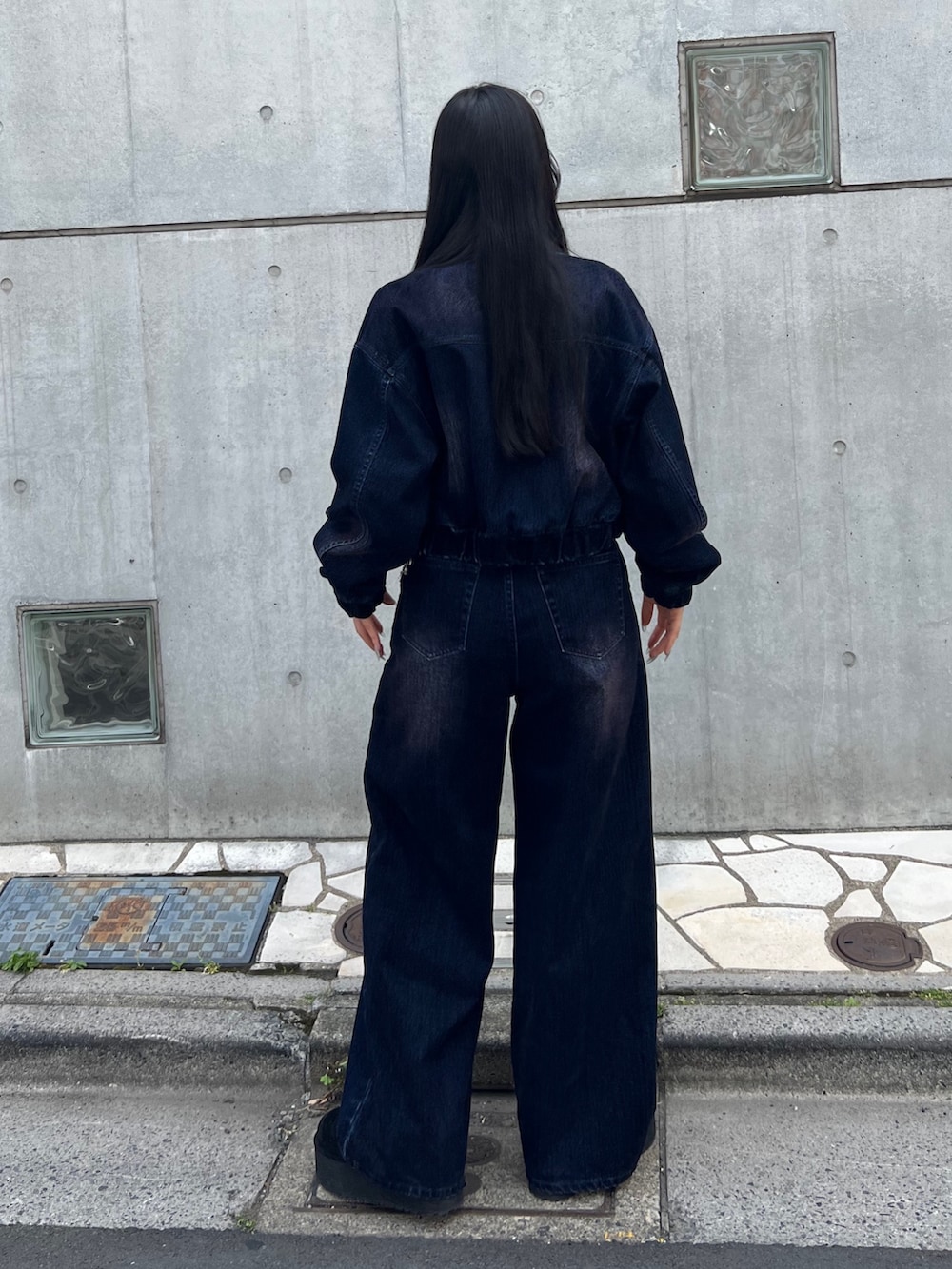 ブルー系のブルゾン、ブルー系のニット/セーター、ブルー系のデニムパンツを着用したレディースの夏コーディネートの3枚目の写真