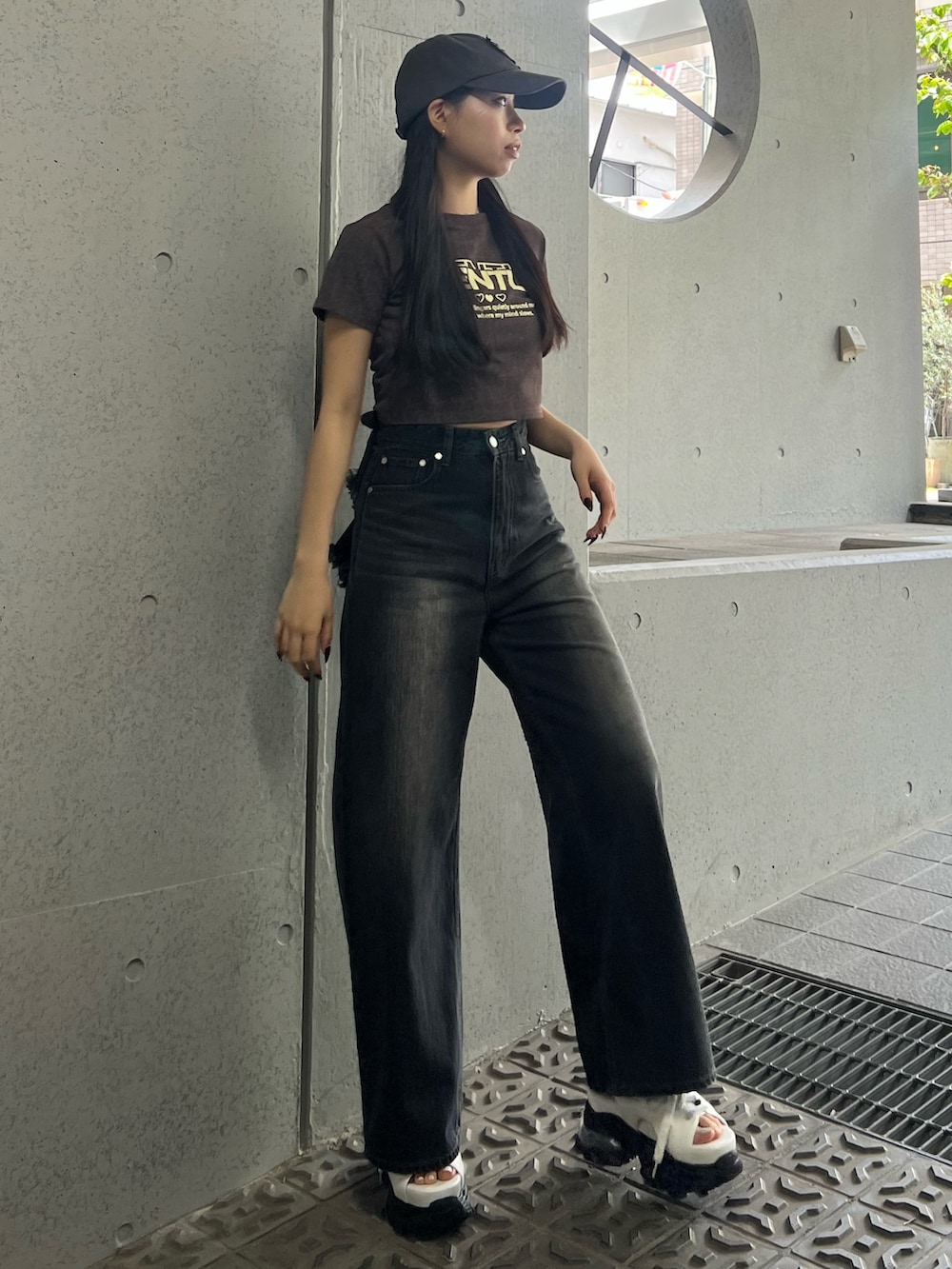 ブラウン系のTシャツ/カットソー、ホワイト系のサンダル、ブラック系のデニムパンツを着用したレディースの夏コーディネートの2枚目の写真