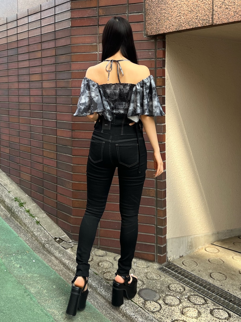 ブラック系のデニムパンツ、ブラック系のサンダルを着用したレディースの春コーディネートの3枚目の写真