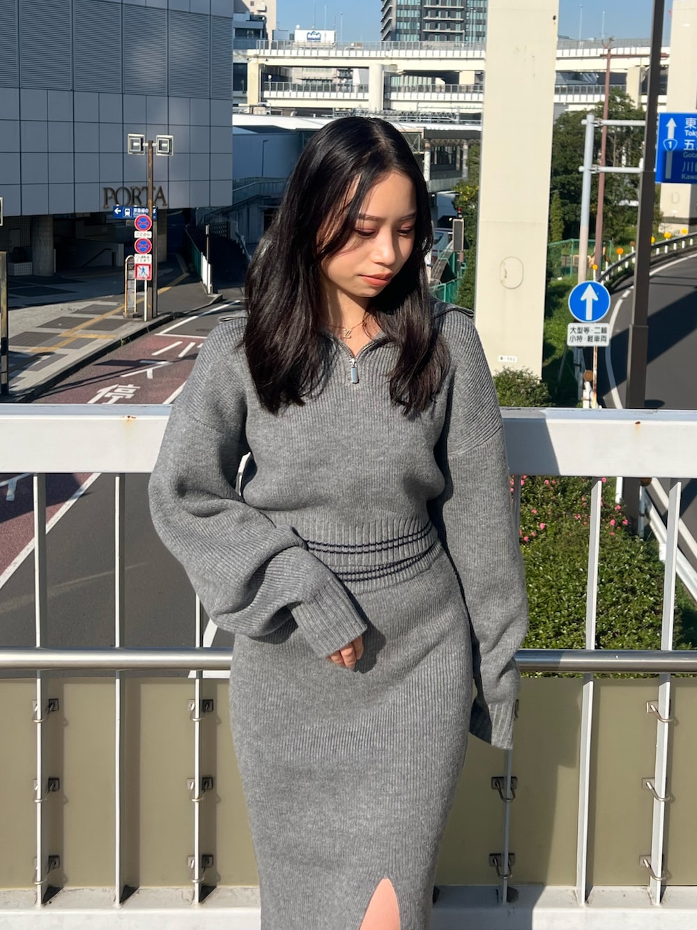 グレー系のスカート、グレー系のニット/セーター、ブラック系のブーツを着用したレディースの秋コーディネートの4枚目の写真