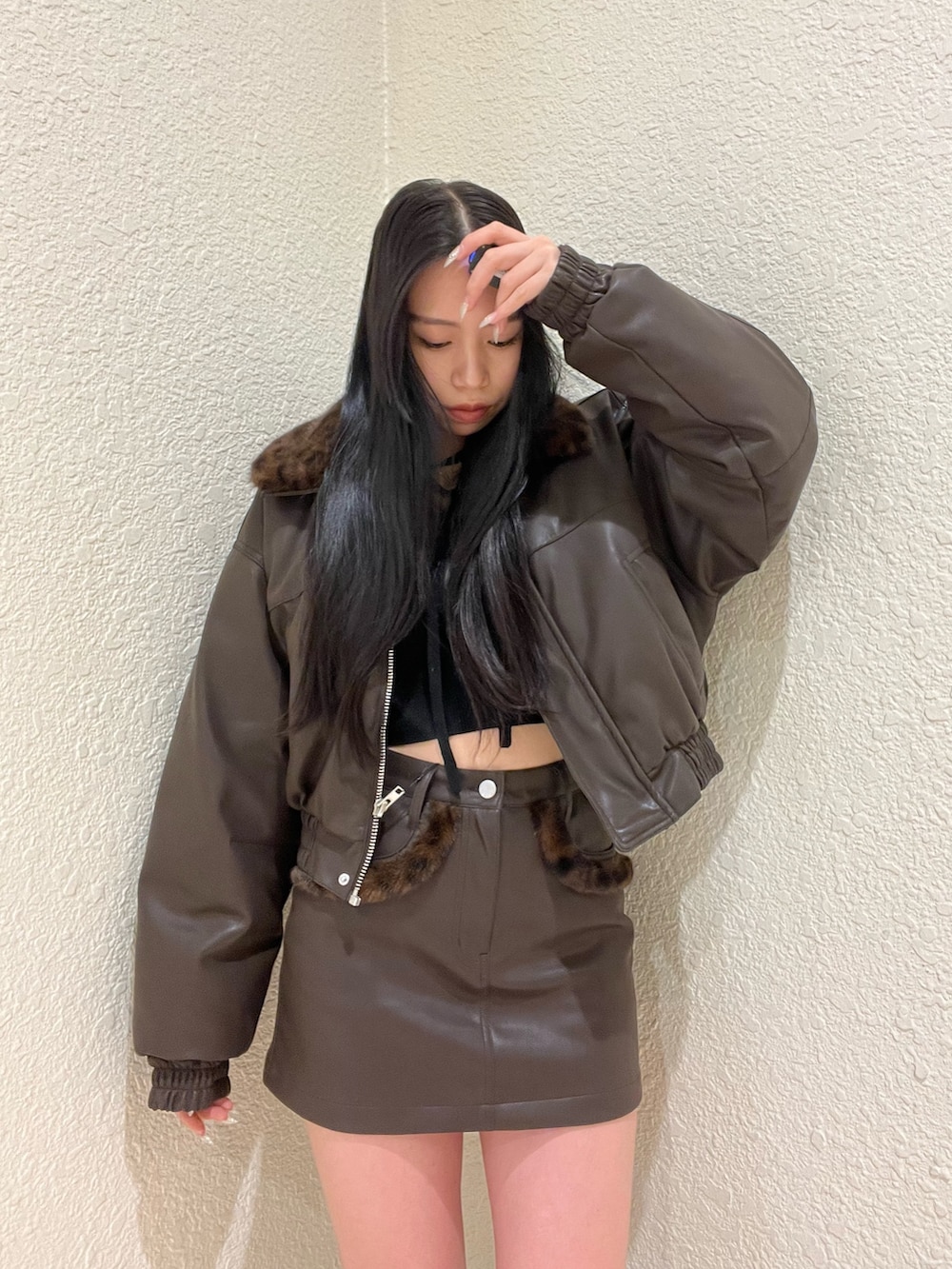 ブラウン系のブルゾン、ブラック系のニット/セーター、ブラウン系のスカートを着用したレディースの冬コーディネートの4枚目の写真