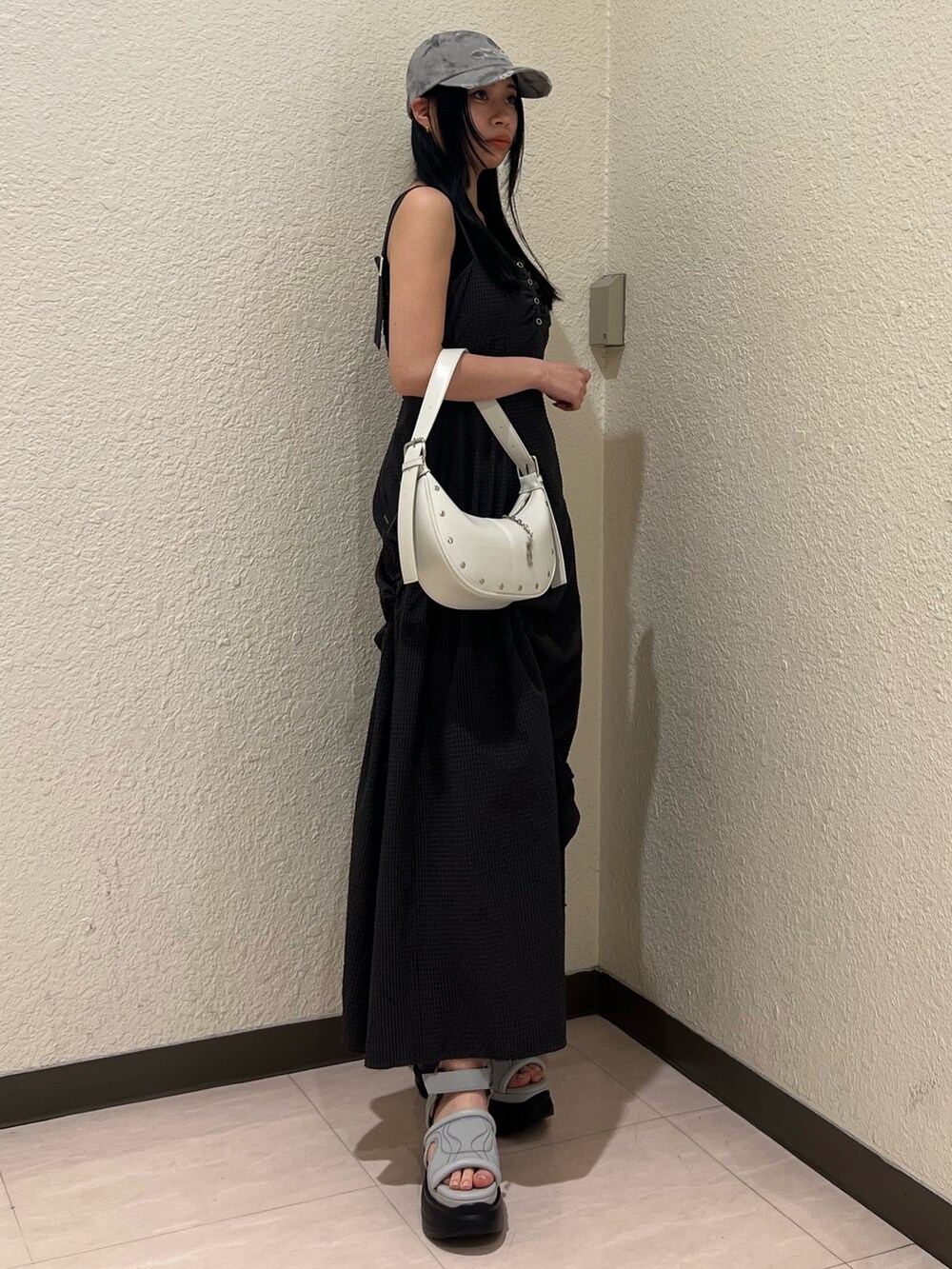 グレー系のワンピース、ホワイト系のハンドバッグ、グレー系のサンダルを着用したレディースの春コーディネートの2枚目の写真