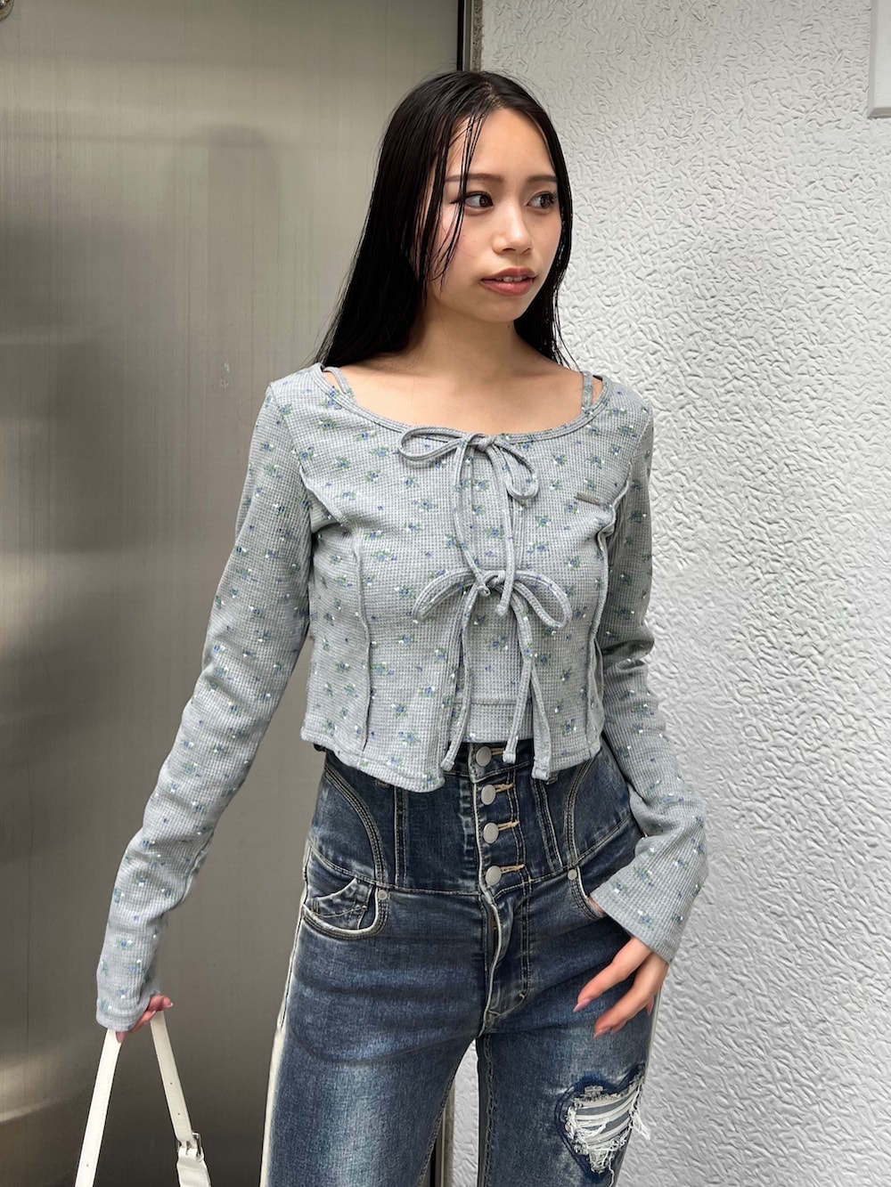 グレー系のTシャツ/カットソー、ブルー系のデニムパンツ、ホワイト系のハンドバッグを着用したレディースの夏コーディネートの4枚目の写真