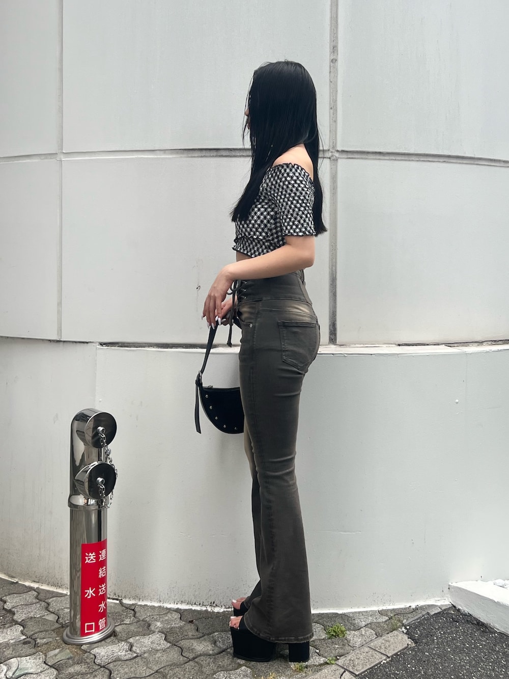 ブラック系のハンドバッグ、ブラック系のサンダル、グレー系のデニムパンツを着用したレディースの夏コーディネートの2枚目の写真