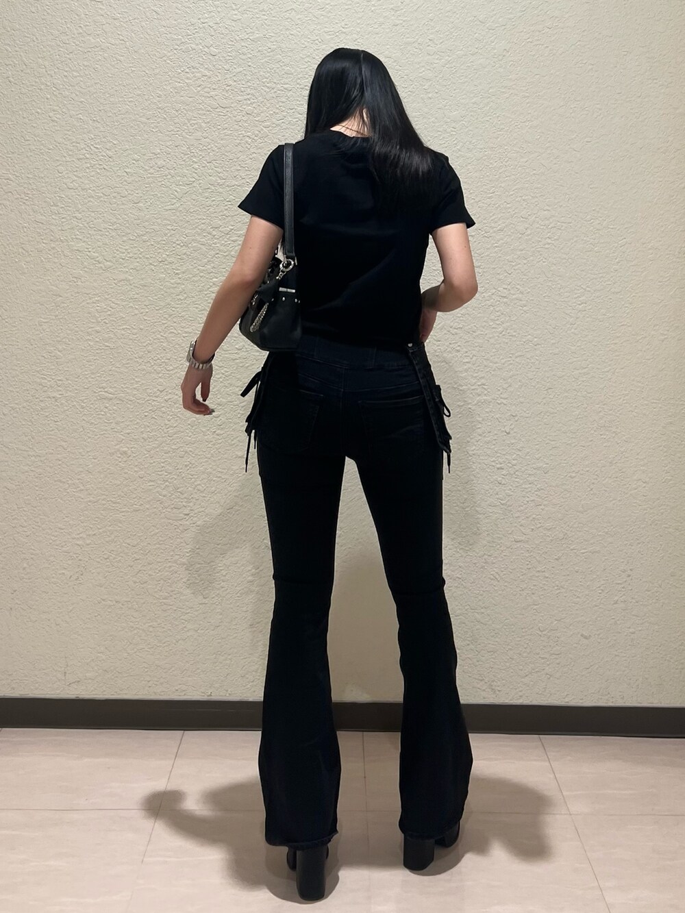 ブラック系のTシャツ/カットソー、ブラック系のハンドバッグ、ブラック系のデニムパンツを着用したレディースの春コーディネートの3枚目の写真