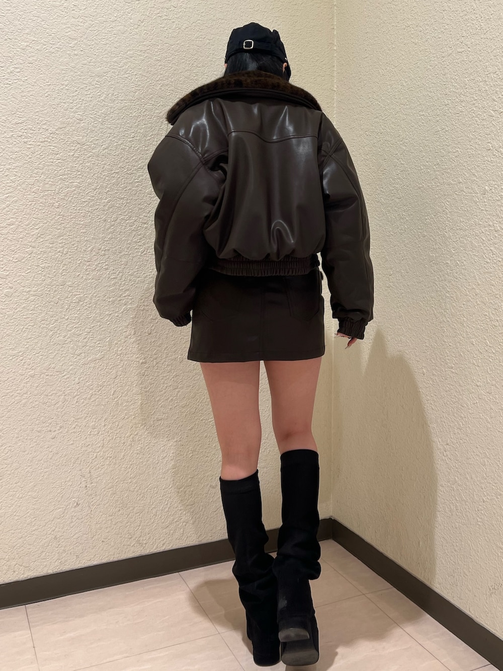 ブラウン系のブルゾン、ブラック系のニット/セーター、ブラウン系のスカートを着用したレディースの冬コーディネートの3枚目の写真