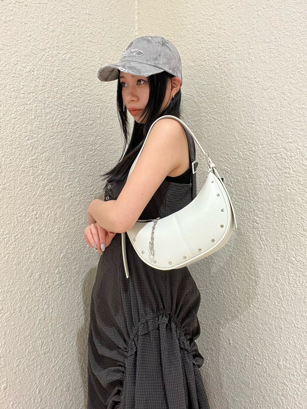 グレー系のワンピース、ホワイト系のハンドバッグ、グレー系のサンダルを着用したレディースの春コーディネートの4枚目の写真