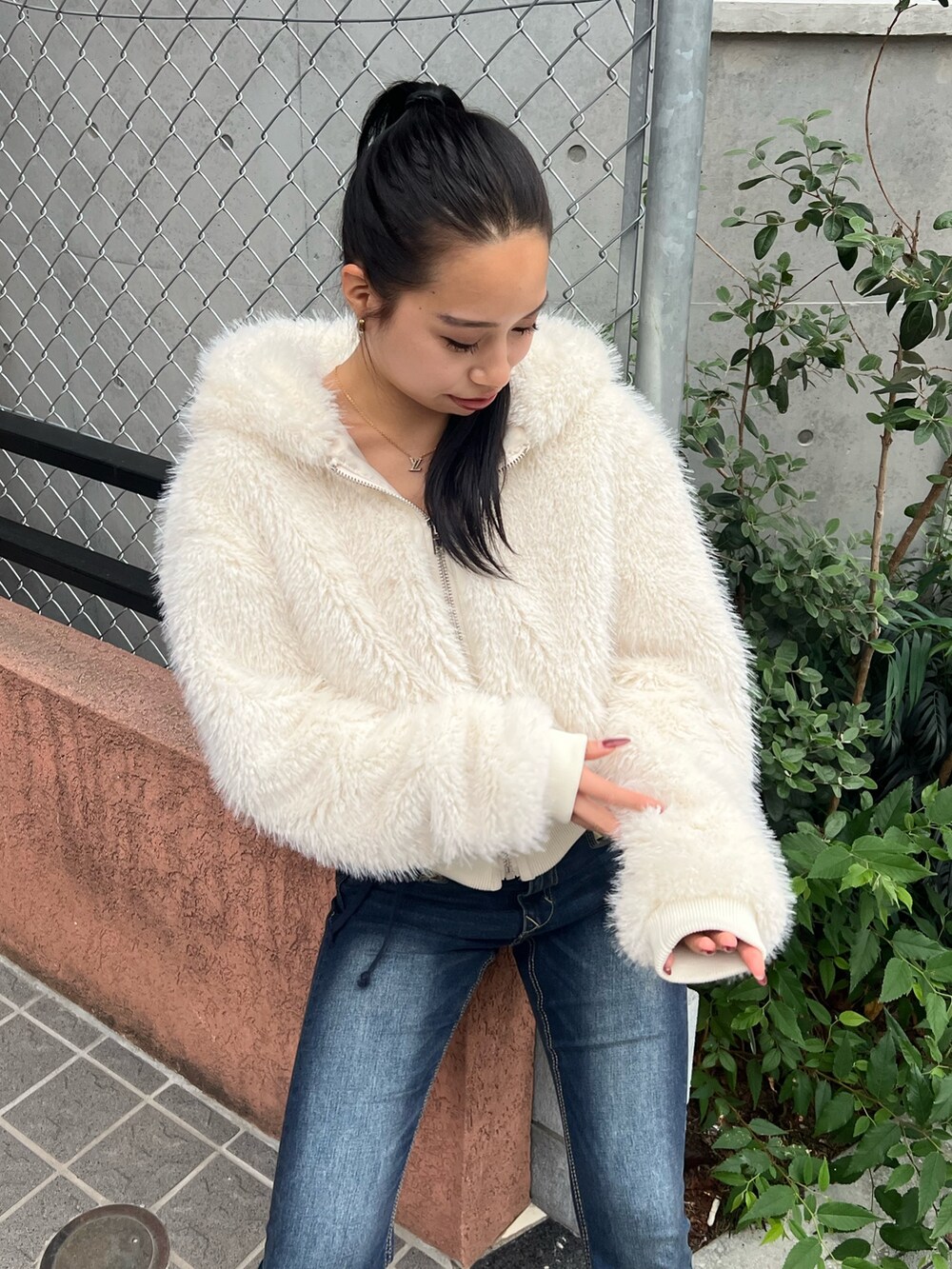 ホワイト系のブルゾン、ブルー系のデニムパンツ、ブラック系のローファーを着用したレディースの秋コーディネートの4枚目の写真