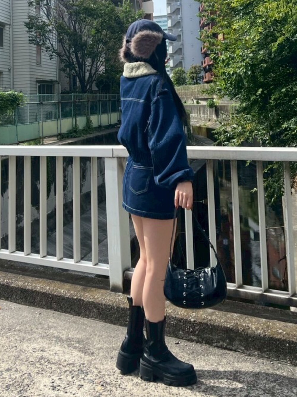 ブラック系のTシャツ/カットソー、ブルー系のブルゾン、ブルー系のスカートを着用したレディースの秋コーディネートの2枚目の写真