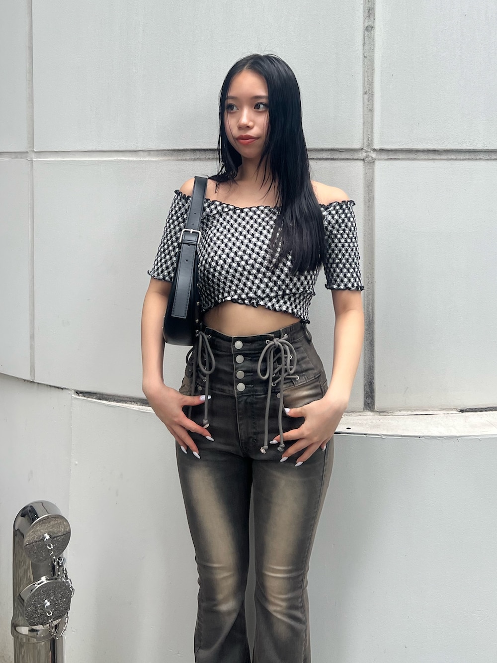 ブラック系のハンドバッグ、ブラック系のサンダル、グレー系のデニムパンツを着用したレディースの夏コーディネートの4枚目の写真