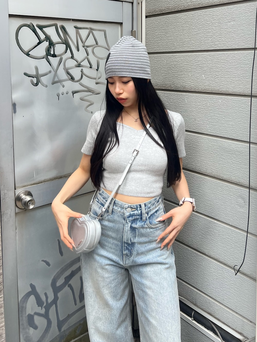 グレー系のニット/セーター、ブルー系のデニムパンツ、グレー系のニットキャップ/ビーニーを着用したレディースの春コーディネートの4枚目の写真