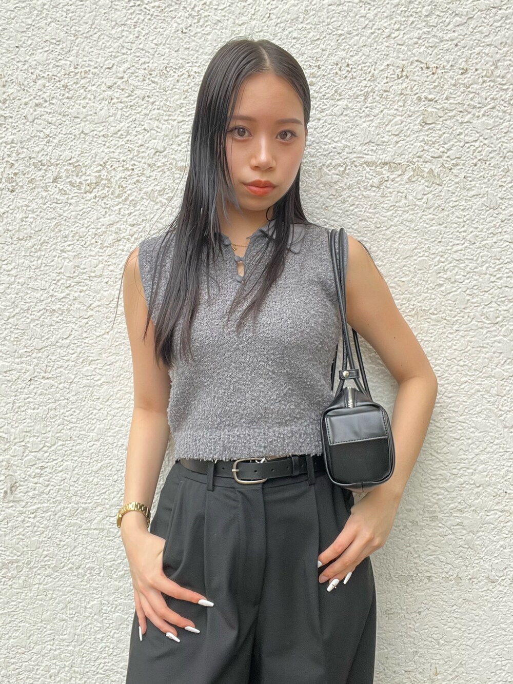 グレー系のニット/セーター、ブラック系のその他パンツ、ブラック系のハンドバッグを着用したレディースの夏コーディネートの4枚目の写真