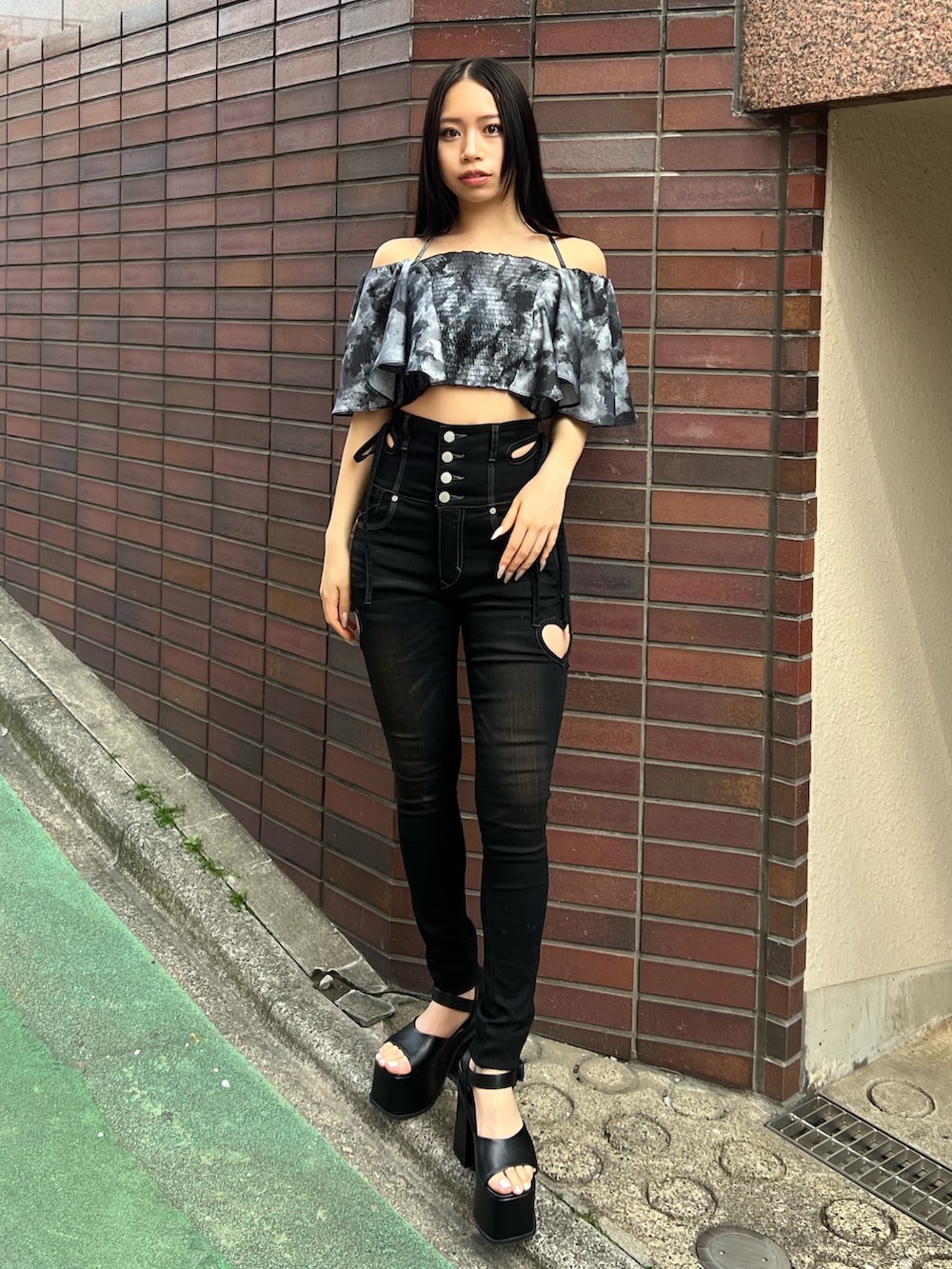 ブラック系のデニムパンツ、ブラック系のサンダルを着用したレディースの春コーディネートの2枚目の写真
