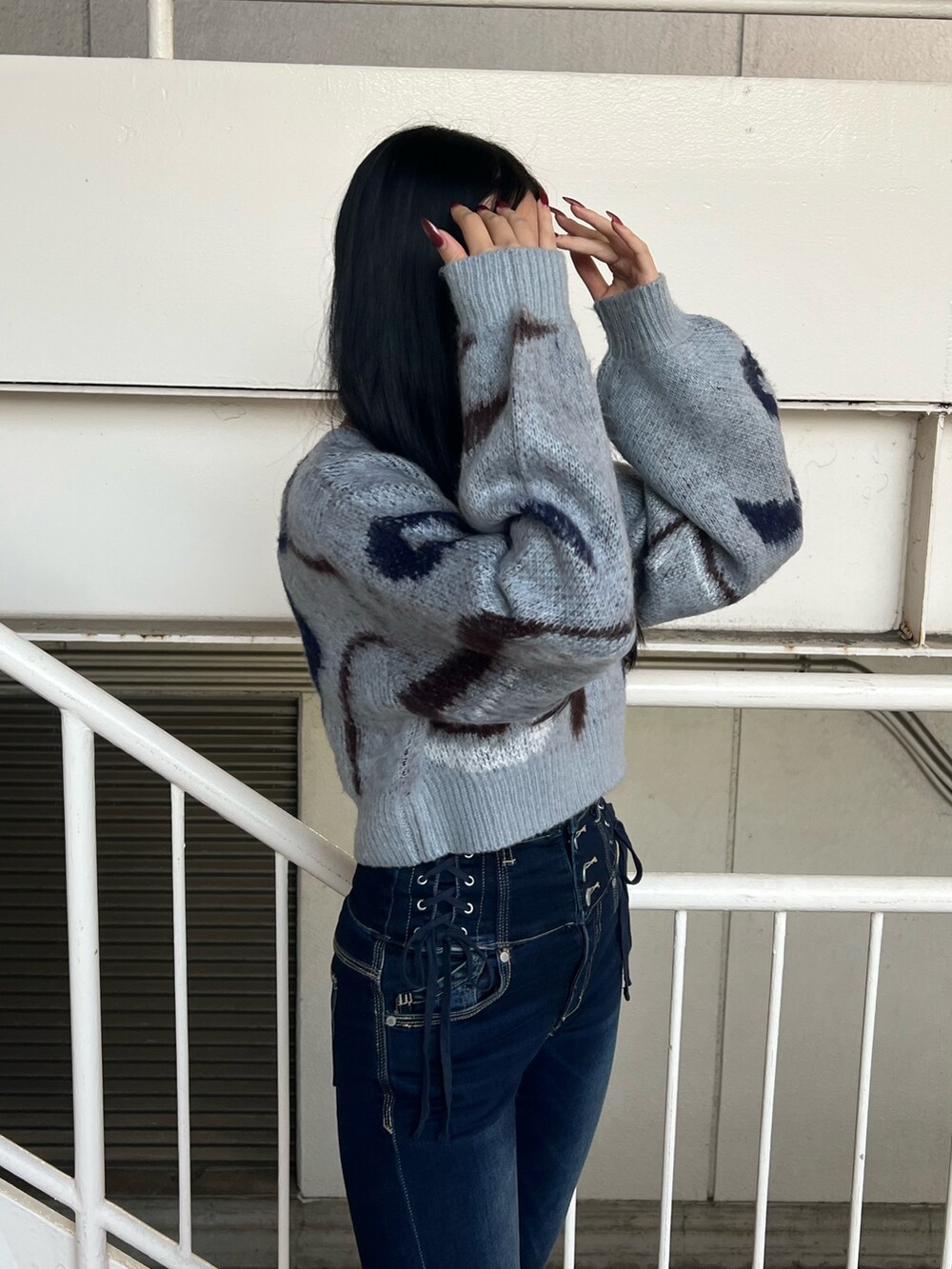 グレー系のニット/セーター、ブルー系のデニムパンツ、ブラック系のブーツを着用したレディースの秋コーディネートの4枚目の写真
