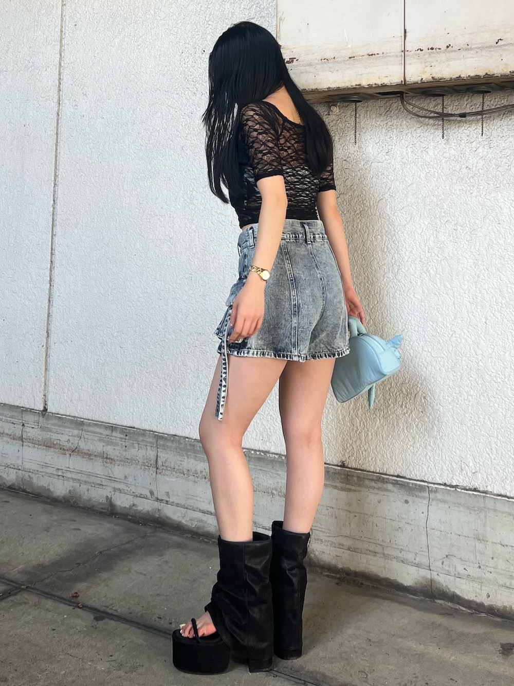 ブラック系のTシャツ/カットソー、ブルー系のスカート、ブラック系のサンダルを着用したレディースの夏コーディネートの3枚目の写真