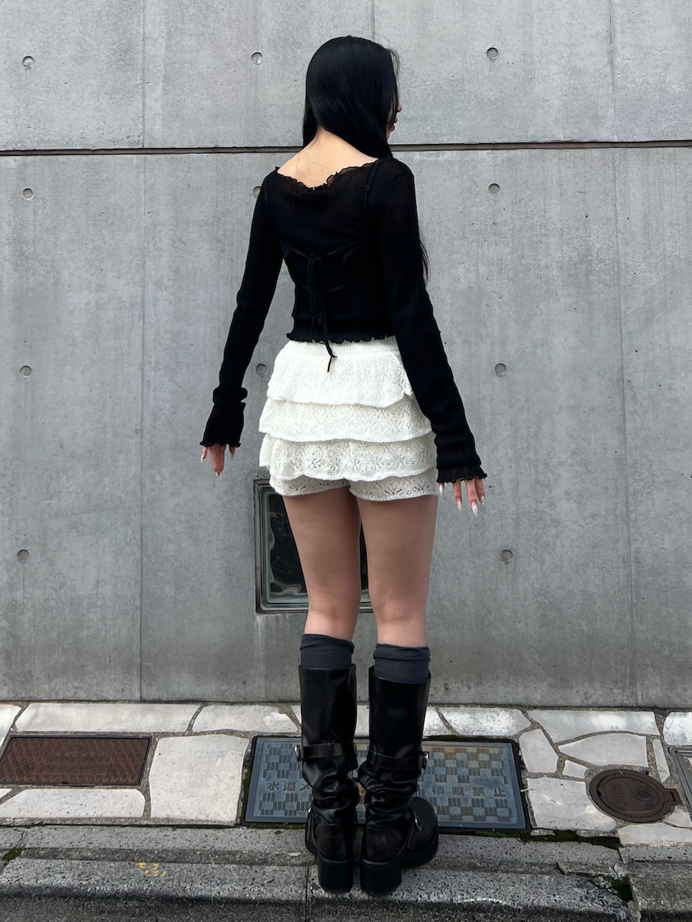 ブラック系のニット/セーター、ホワイト系のスカート、ブラック系のブーツを着用したレディースの冬コーディネートの3枚目の写真