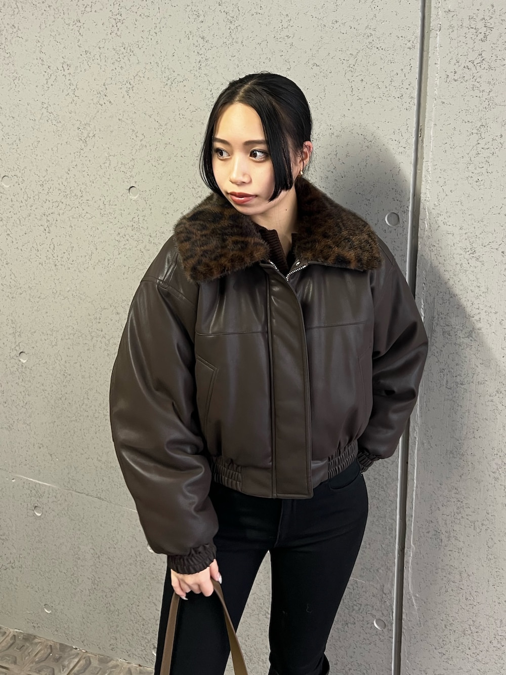 ブラウン系のブルゾン、ブラック系のデニムパンツ、ベージュ系のショルダーバッグを着用したレディースの冬コーディネートの4枚目の写真