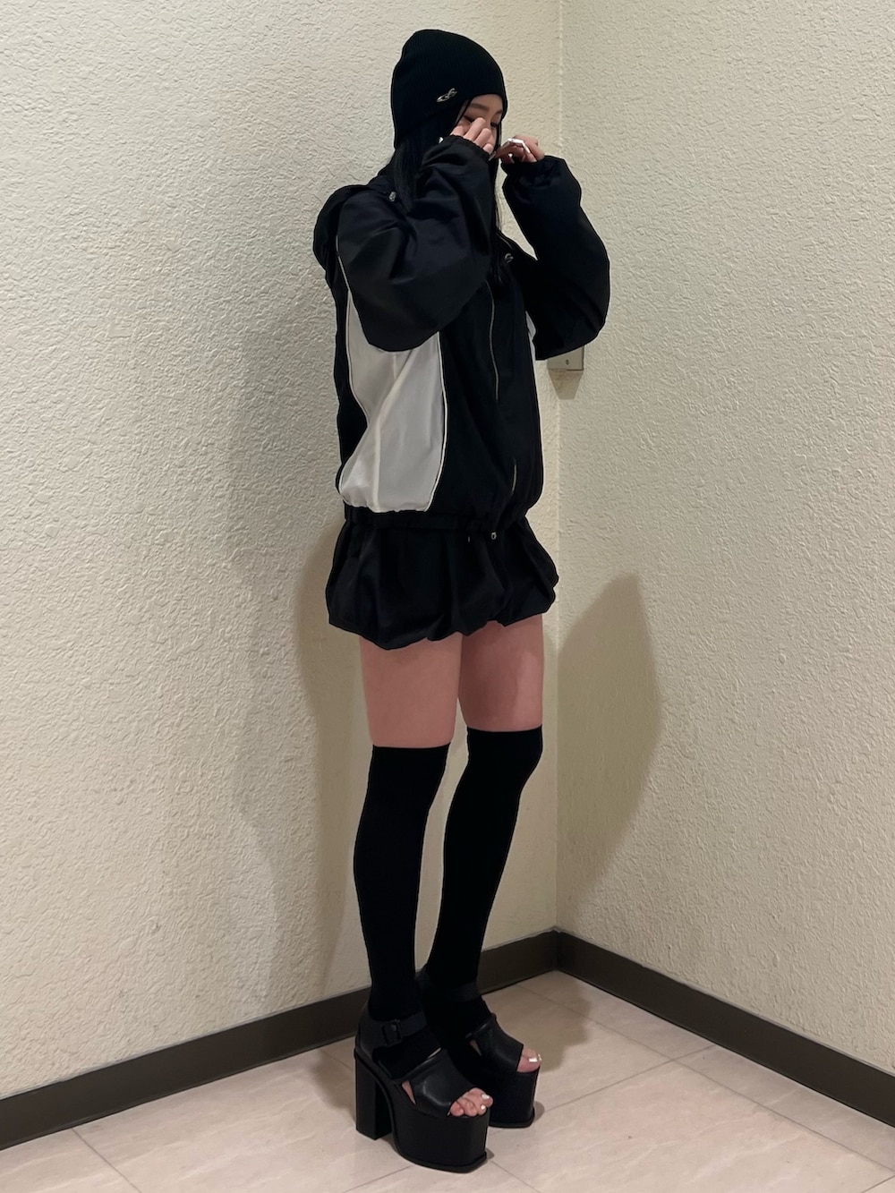ブラック系のスカート、ブラック系のブルゾン、ブラック系のサンダルを着用したレディースの春コーディネートの2枚目の写真