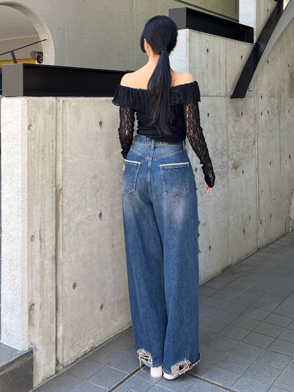 ブラック系のTシャツ/カットソー、ブルー系のデニムパンツ、ホワイト系のサンダルを着用したレディースの冬コーディネートの3枚目の写真