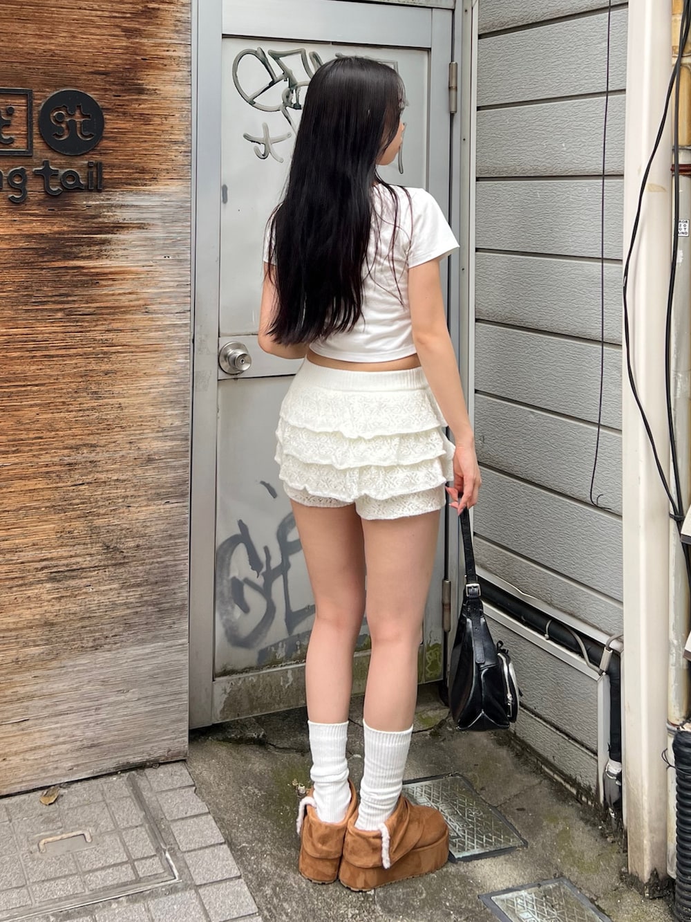 ホワイト系のTシャツ/カットソー、ホワイト系のスカート、ブラック系のハンドバッグを着用したレディースの秋コーディネートの3枚目の写真