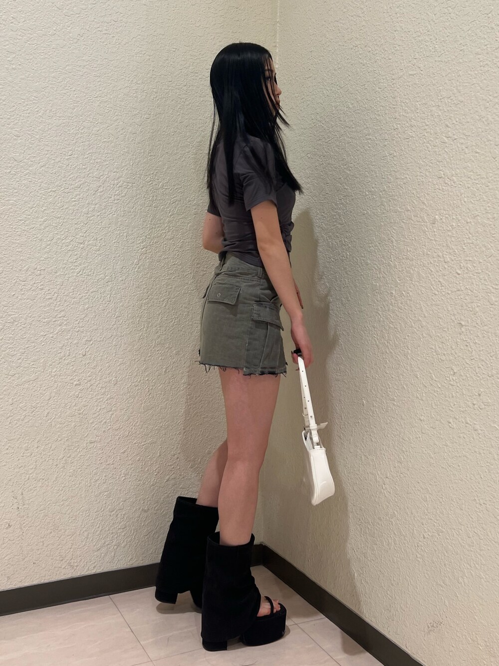 グレー系のTシャツ/カットソー、グレー系のスカート、ブラック系のサンダルを着用したレディースの春コーディネートの2枚目の写真