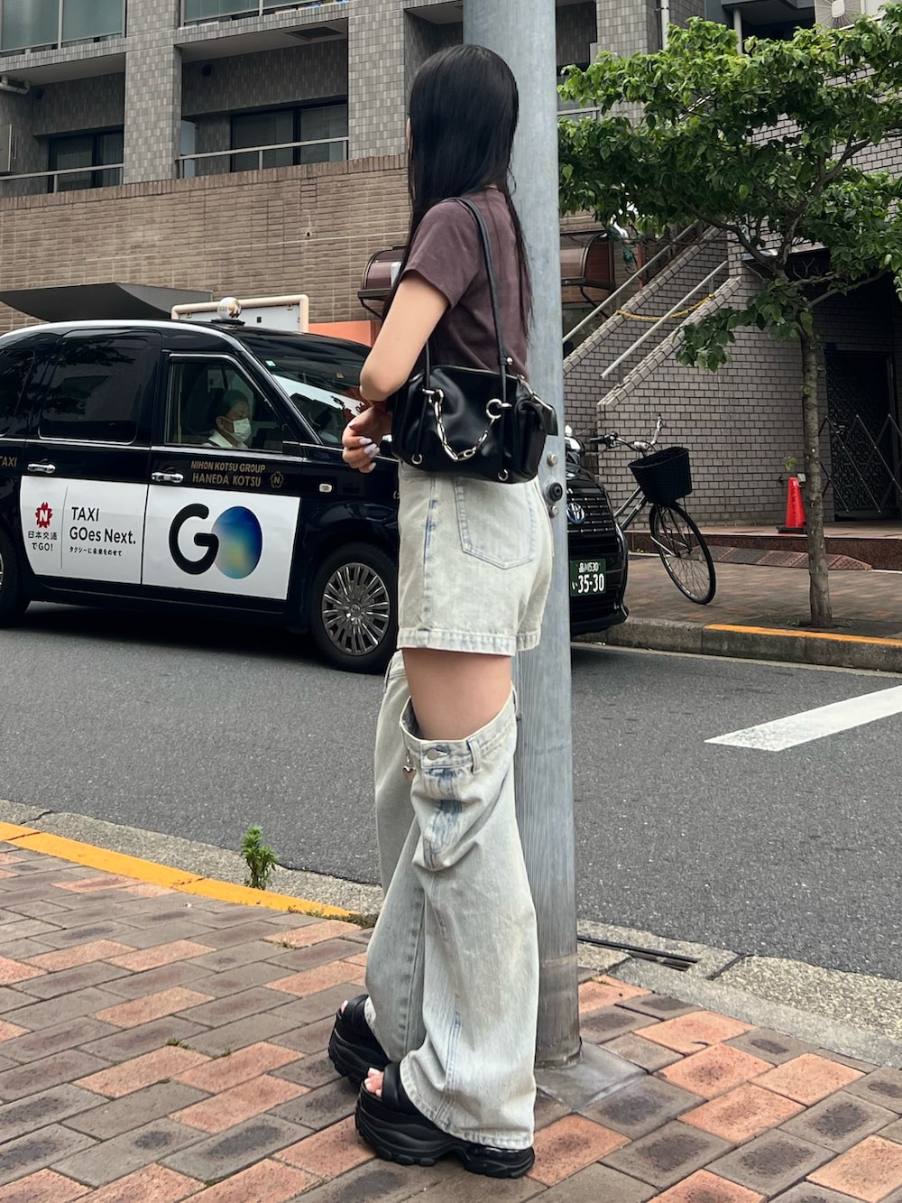 ブラウン系のTシャツ/カットソー、ブルー系のデニムパンツ、ブラック系のサンダルを着用したレディースの夏コーディネートの2枚目の写真