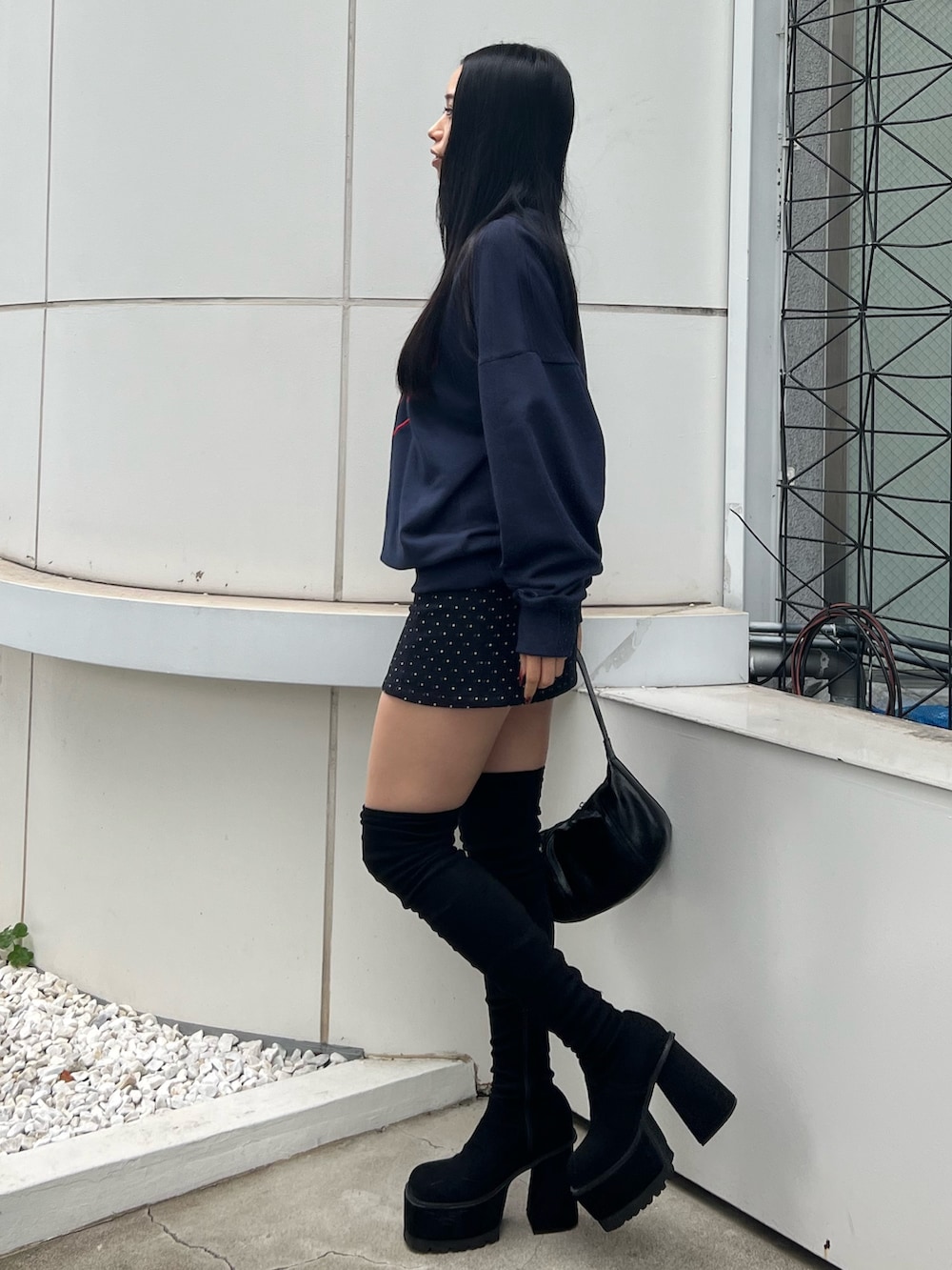 ブルー系のスウェット、ブルー系のスカート、ブラック系のブーツを着用したレディースの秋コーディネートの2枚目の写真