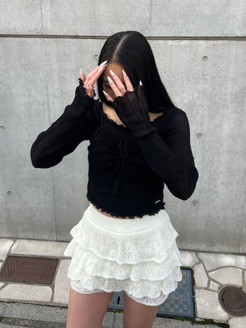 ブラック系のニット/セーター、ホワイト系のスカート、ブラック系のブーツを着用したレディースの冬コーディネートの4枚目の写真