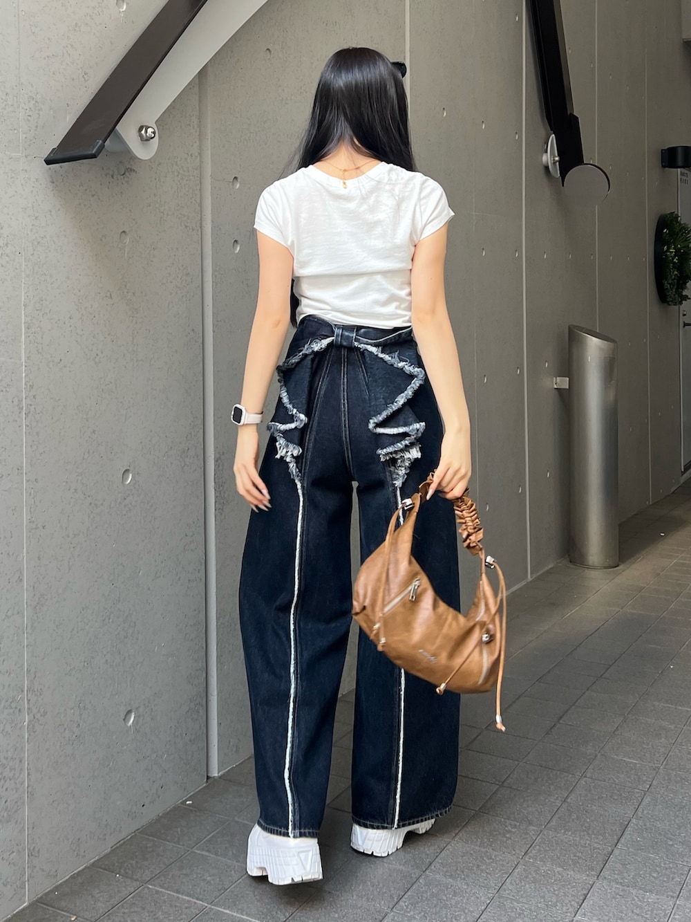 ホワイト系のTシャツ/カットソー、ブルー系のデニムパンツを着用したレディースの春コーディネートの3枚目の写真