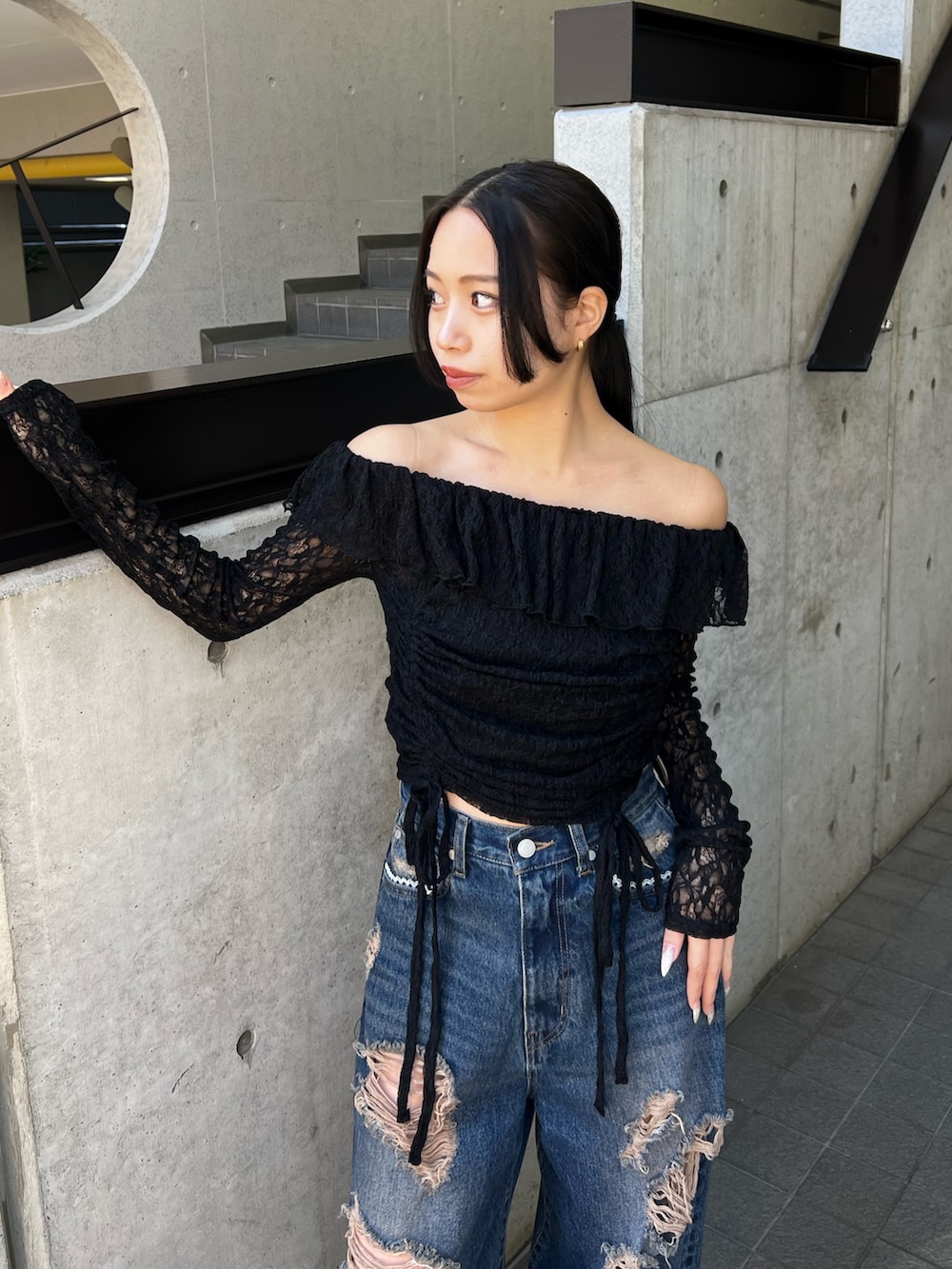 ブラック系のTシャツ/カットソー、ブルー系のデニムパンツ、ホワイト系のサンダルを着用したレディースの冬コーディネートの4枚目の写真