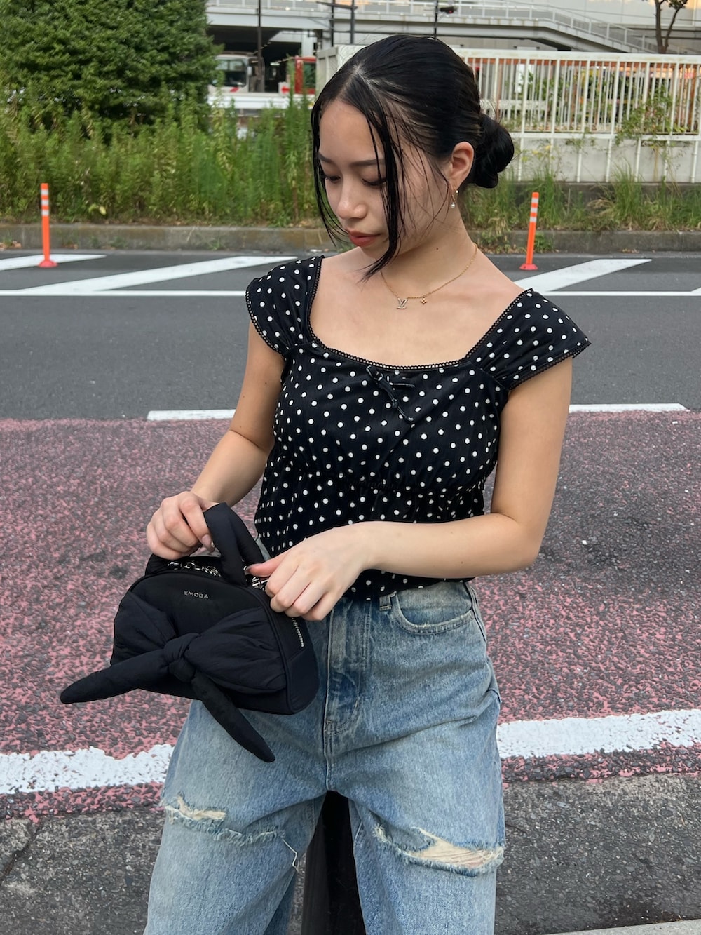 ブラック系のタンクトップ、ブルー系のデニムパンツ、ブラック系のハンドバッグを着用したレディースの夏コーディネートの4枚目の写真