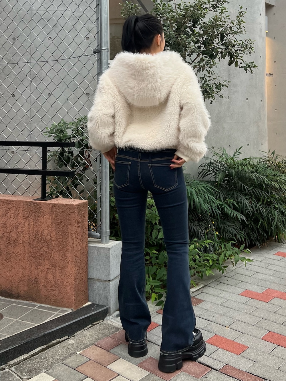 ホワイト系のブルゾン、ブルー系のデニムパンツ、ブラック系のローファーを着用したレディースの秋コーディネートの3枚目の写真