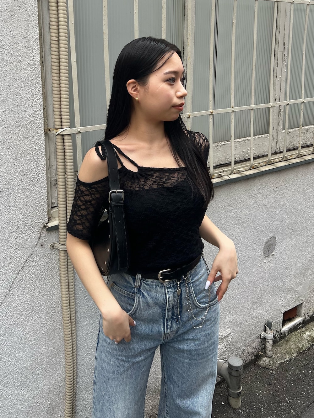ブルー系のデニムパンツ、ブラック系のTシャツ/カットソー、ブラック系のハンドバッグを着用したレディースの夏コーディネートの4枚目の写真
