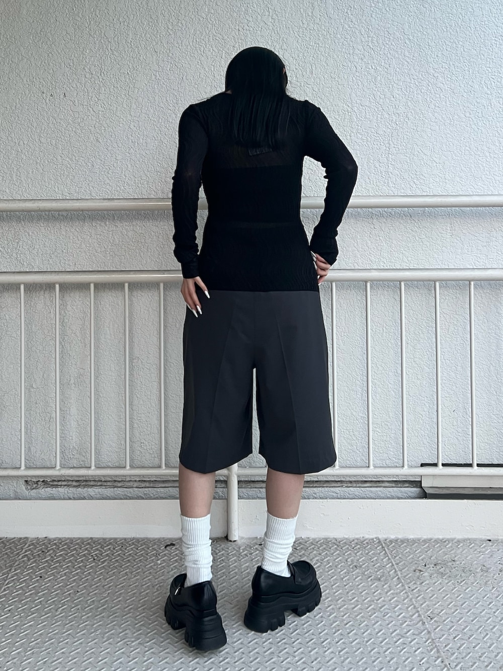 グレー系のその他パンツ、ブラック系のニット/セーター、ブラック系のローファーを着用したレディースの春コーディネートの3枚目の写真