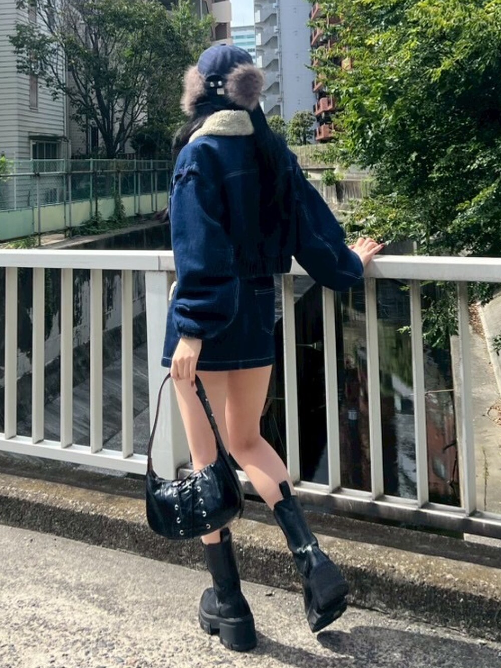 ブラック系のTシャツ/カットソー、ブルー系のブルゾン、ブルー系のスカートを着用したレディースの秋コーディネートの3枚目の写真