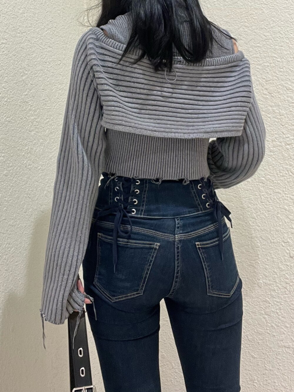 ブルー系のデニムパンツ、グレー系のニット/セーター、ブラック系のハンドバッグを着用したレディースの秋コーディネートの4枚目の写真