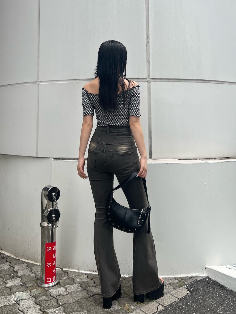 ブラック系のハンドバッグ、ブラック系のサンダル、グレー系のデニムパンツを着用したレディースの夏コーディネートの3枚目の写真