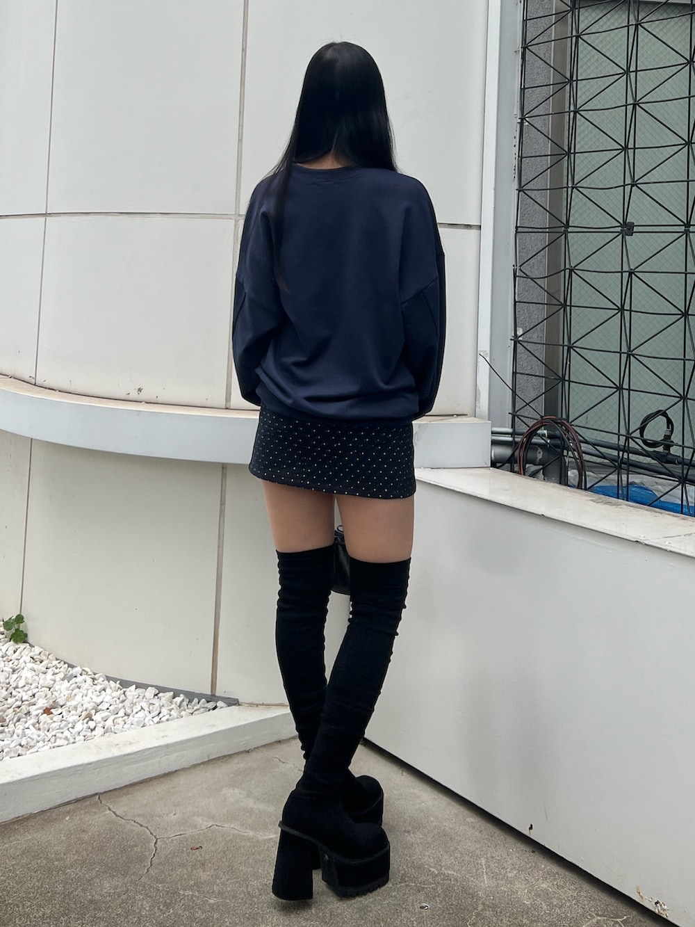 ブルー系のスウェット、ブルー系のスカート、ブラック系のブーツを着用したレディースの秋コーディネートの3枚目の写真